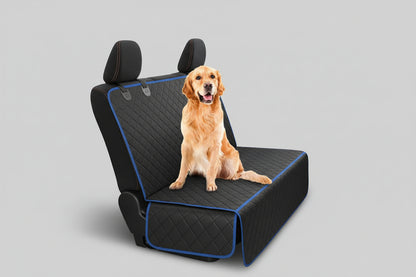 Dog sitting on a car seat cover in a vehicle with a forest view outside.