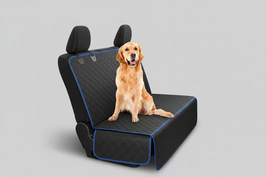 Dog sitting on a car seat cover in a vehicle with a forest view outside.